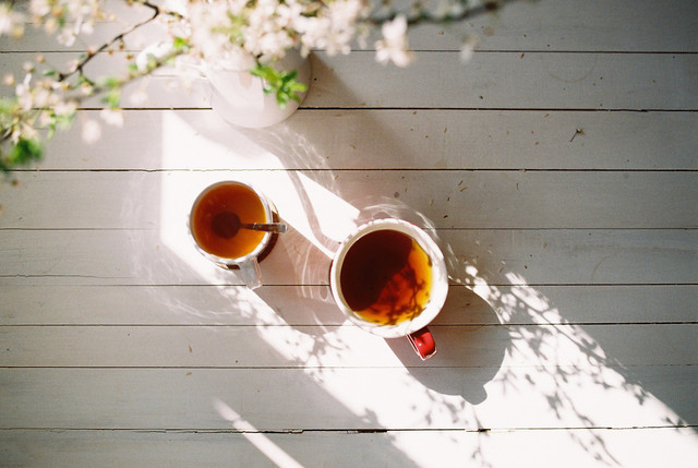 Một người đang tập yoga trên bãi biển vào lúc bình minh, tượng trưng cho việc chăm sóc sức khỏe và tinh thần.