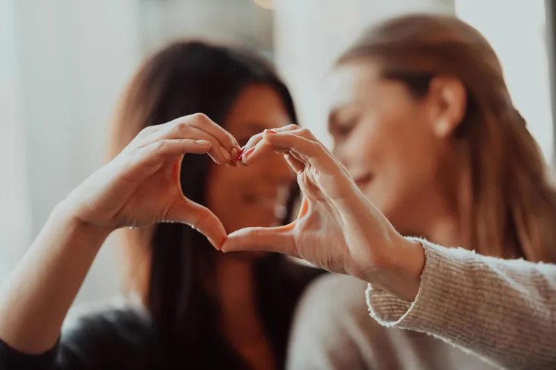 Một cặp đôi cao tuổi nắm tay nhau đi trên bãi biển vào buổi hoàng hôn, tượng trưng cho tình yêu gắn bó và bền chặt theo thời gian