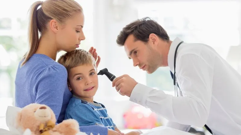 Bác sĩ đang thăm khám tai cho một bệnh nhân bằng dụng cụ y tế