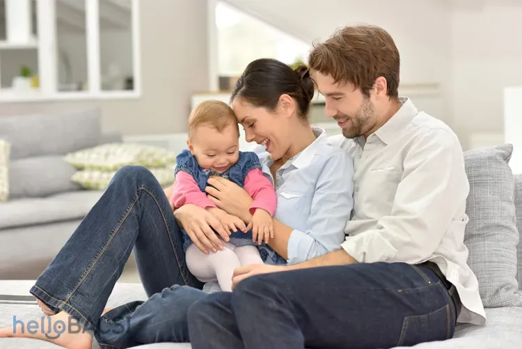 Một em bé sơ sinh đang được mẹ bế bổng lên trong không khí hạnh phúc và vui tươi