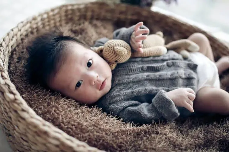Hình ảnh một em bé sơ sinh đang nằm ngủ yên bình, được bao bọc trong chiếc chăn ấm áp